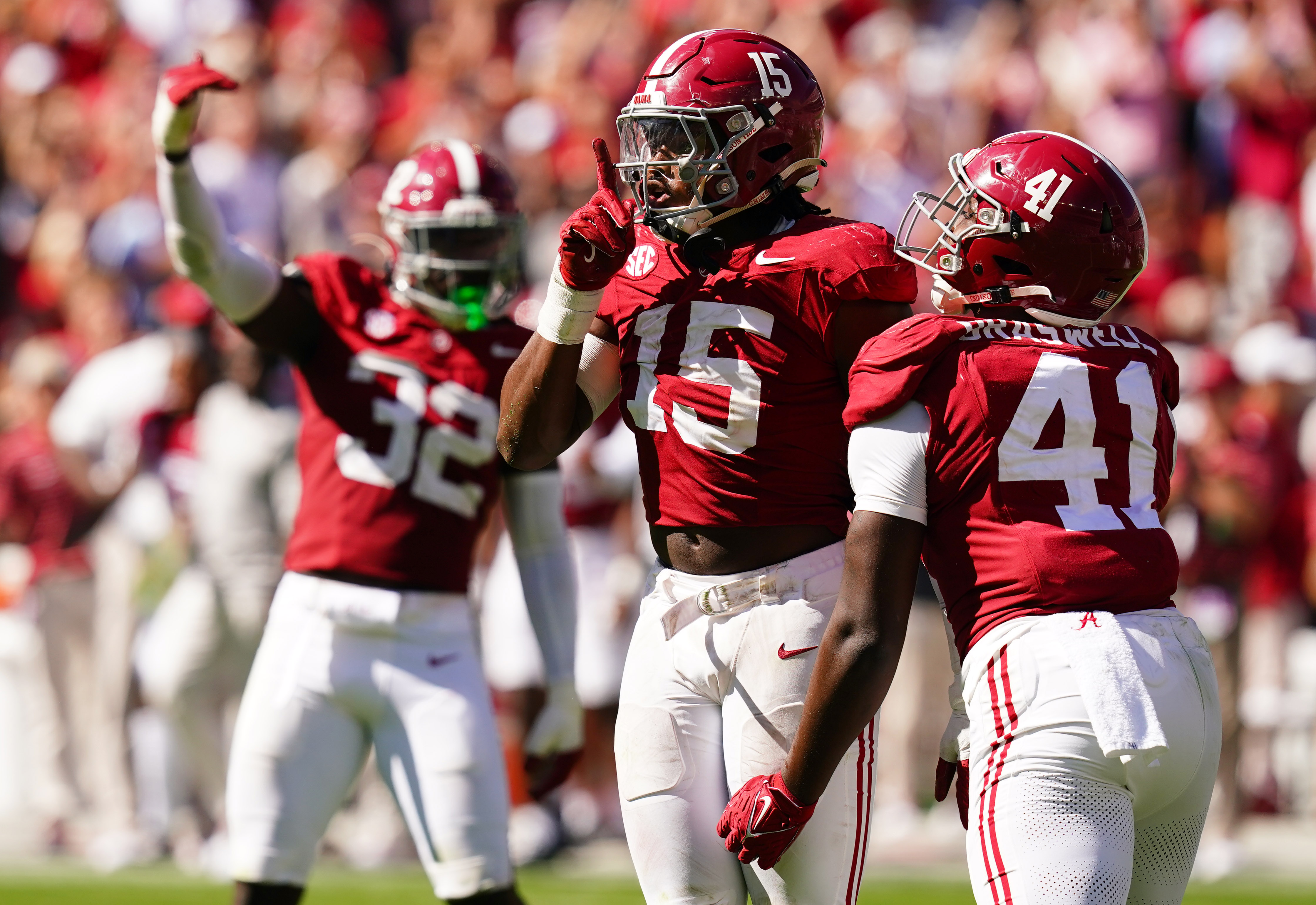 Dallas Turner puts his finger up in front of his mouth in a shushing move as another player runs up to celebrate with him